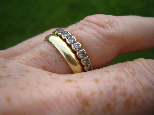 n äldre persons hand. två ringar på ett finger, en med stenar.