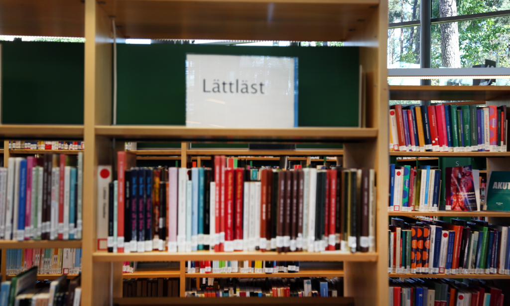 Böcker i en bokhylla. Överst i hyllan en vit skylt med texten Lättläst.
