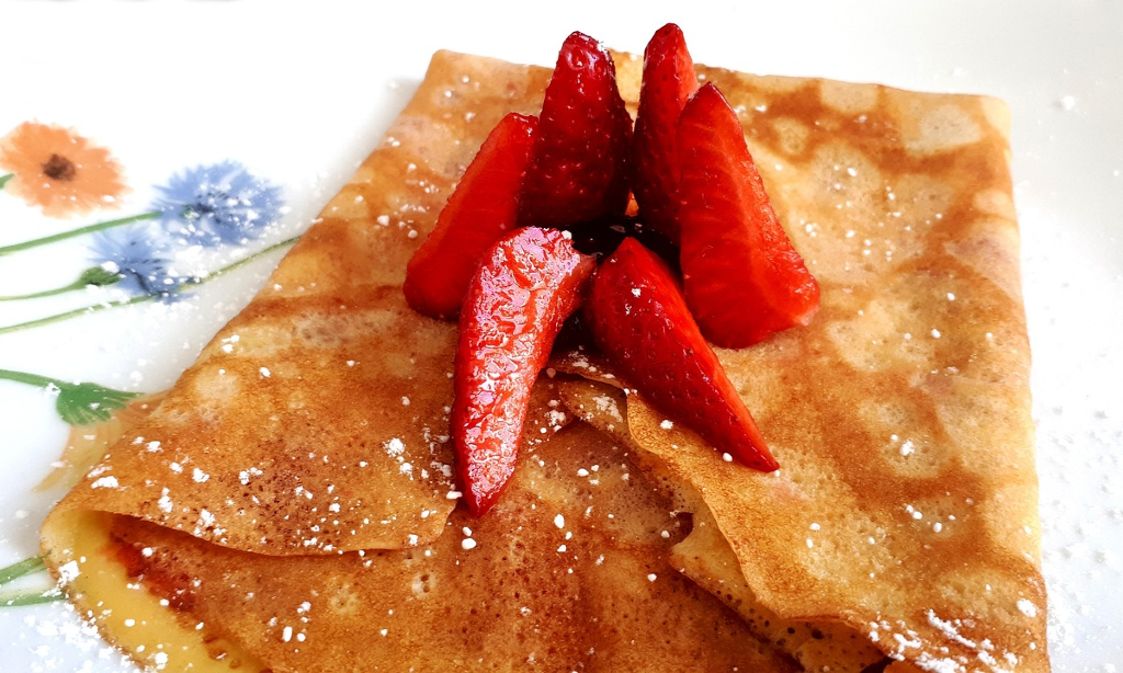 Crepes med jordgubbsbitar på.
