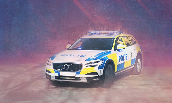Uppställd polisbil utomhus med ljussken från lampor.