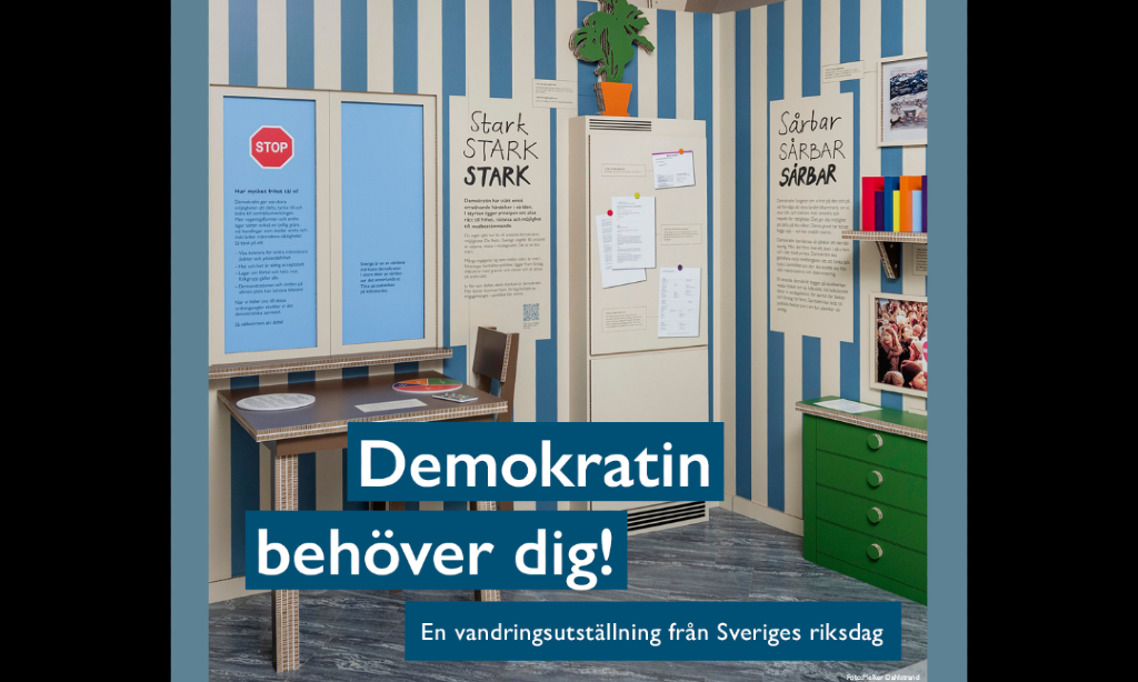 Demokratiutställningen med blårandiga tapeter på väggarna. Det står sårbar ggr flera och stark ggr flera.
