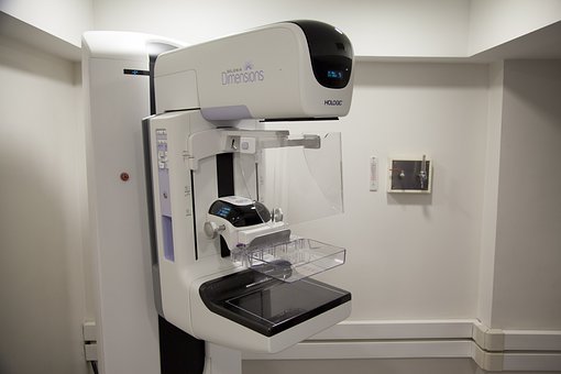 Röntgenapparat för mammografi. Den är vit och väggarna är vita.