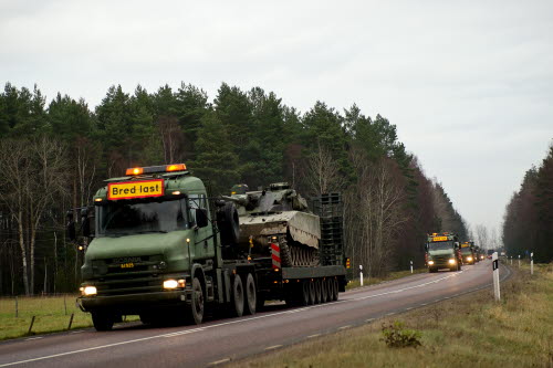 Militärlastbilar på vägen lastade med militärutrustning