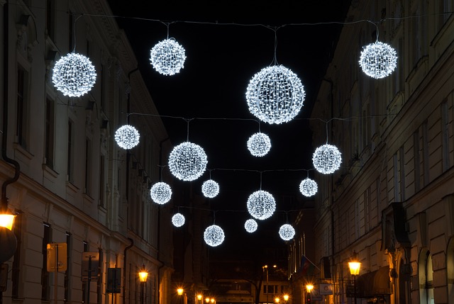 Julbelysning i en stad. Lamporna som hänger ser ut som gnistrande snöbollar.