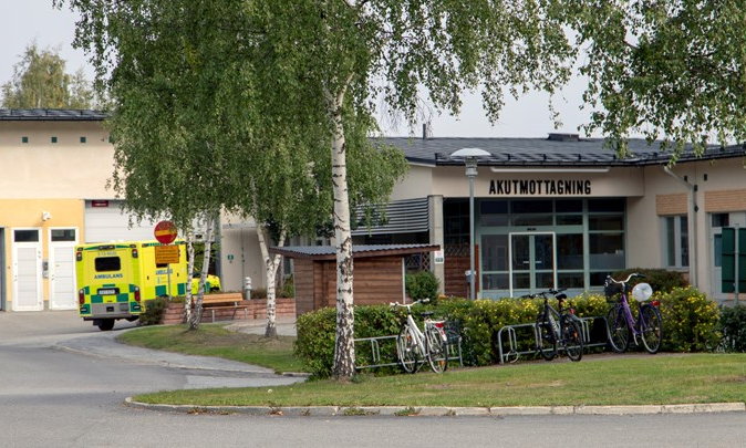 akutmottagningens utsida på sollefteå sjukhus. cyklar på rad i cykelställ. ambulans står utanför ingången.