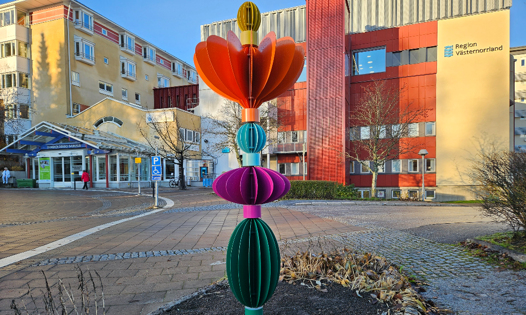 Skulpturen Alata i dagsljus med sjukhuset i bakgrunden.